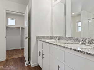 Bathroom with double vanity and hardwood / wood-style flooring