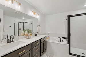 Bathroom with tile flooring, independent shower and bath, dual sinks, and vanity with extensive cabinet space