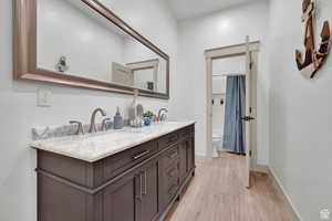 Bathroom with double sink vanity, toilet, and hardwood / wood-style flooring