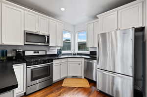 White cabinets , granite countertops, gas range