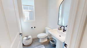 Powder bathroom featuring a healthy amount of sunlight, tile flooring, sink, and toilet