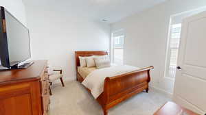 Secondary bedroom featuring light colored carpet