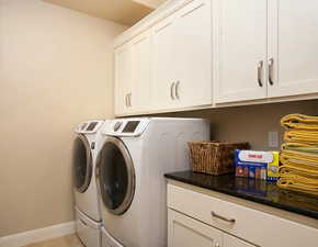 Laundry room featuring washer and dryer and cabinets