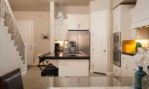 Kitchen with sink, stainless steel appliances, decorative light fixtures, and white cabinetry