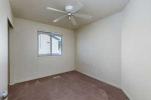 Empty room featuring carpet floors and ceiling fan