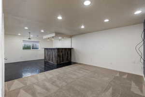 Carpeted spare room with a textured ceiling and bar area