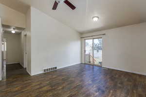 Spare room featuring high vaulted ceiling, ceiling fan, and dark hardwood / wood-style floors