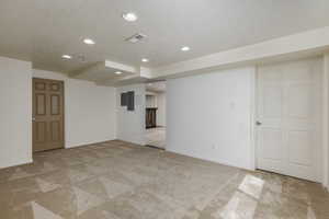 Carpeted spare room with a textured ceiling