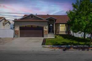 Ranch-style house featuring a garage and a lawn