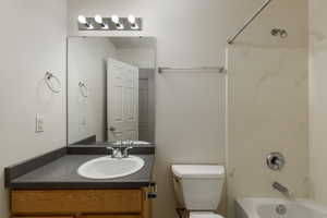 Full bathroom with bathing tub / shower combination, vanity, and toilet