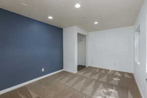 Carpeted spare room with a textured ceiling