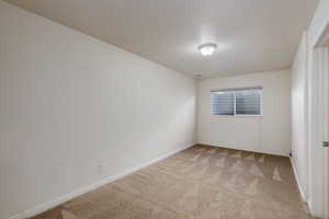 Spare room featuring light colored carpet