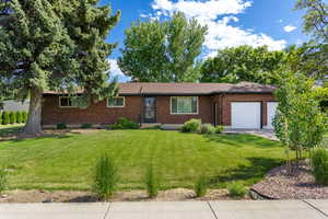 Ranch-style home with a garage and a front yard