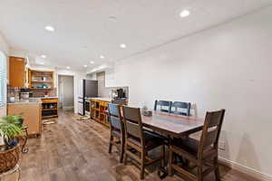 Dining space with wood-type flooring and a textured ceiling