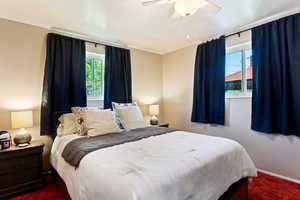 Carpeted bedroom featuring ceiling fan