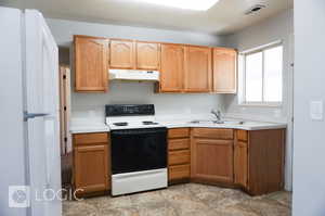 Kitchen with sink, light tile flooring, and white appliances