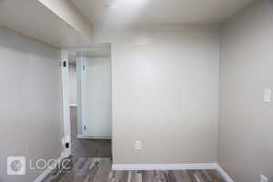 Empty room with dark hardwood / wood-style flooring