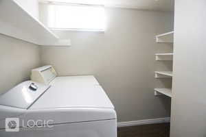 Clothes washing area with hardwood / wood-style floors and washing machine and clothes dryer