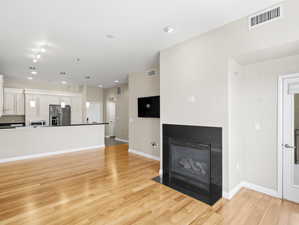 Unfurnished living room featuring track lighting and light hardwood / wood-style flooring