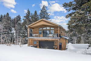 View of front of home featuring a garage and a balcony