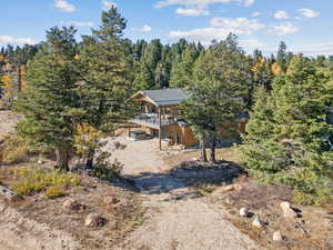 Aerial view of property and surrounding area with a forest