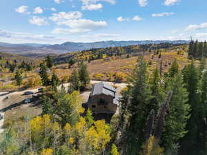 View from above of property with a mountain backdrop and a forest