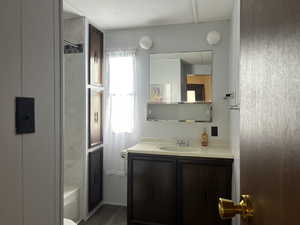 Bathroom with shower / bathtub combination, vanity, and hardwood / wood-style floors