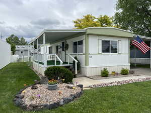 Manufactured / mobile home with a front yard and covered porch