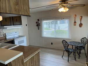 Kitchen featuring ceiling fan, white range with electric stovetop, and light hardwood / wood-style floors