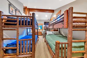 Bedroom with wood-type flooring and vaulted ceiling with beams