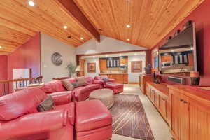 Living room featuring light colored carpet and vaulted ceiling with beams