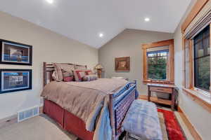 Bedroom with wood-type flooring and vaulted ceiling