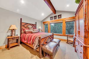 Bedroom with vaulted ceiling with beams