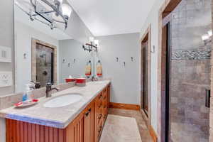 Bathroom featuring walk in shower, oversized vanity, and tile floors