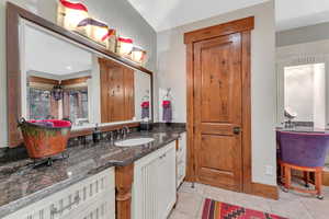 Bathroom with tile floors, vanity, and a bathtub