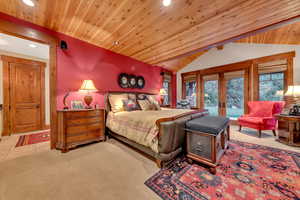 Carpeted bedroom featuring wooden ceiling, french doors, and lofted ceiling