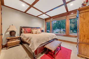 Carpeted bedroom featuring coffered ceiling