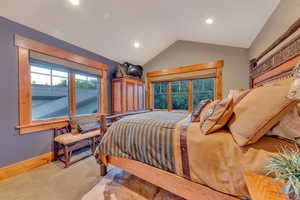 Carpeted bedroom featuring vaulted ceiling