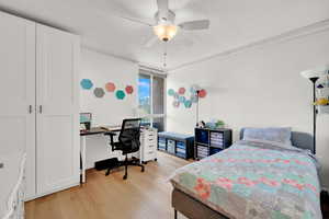 Bedroom featuring ceiling fan, light hardwood / wood-style flooring, and a textured ceiling