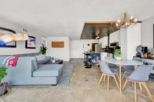 Living room with a notable chandelier and light tile flooring