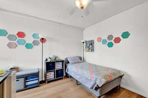 Bedroom featuring ceiling fan, a textured ceiling, and hardwood / wood-style flooring