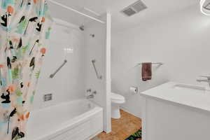 Full bathroom featuring tile flooring, vanity, toilet, and shower / tub combo