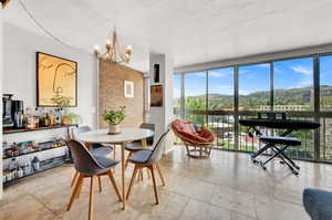 Tiled dining space featuring a notable chandelier and a mountain view