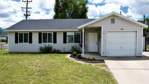 Ranch-style home with a front lawn and a garage