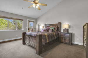 Carpeted bedroom with high vaulted ceiling and ceiling fan