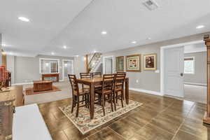 Dining area featuring dark tile flooring and a textured ceiling