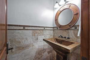 Bathroom with tile walls and tasteful backsplash