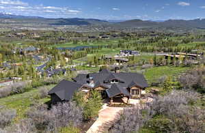 Aerial Drone View Featuring the Golf Course, Pond & Mountains Beyond