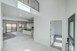 Hall featuring a high ceiling and light tile floors