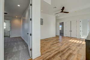 Entryway with ceiling fan and light carpet